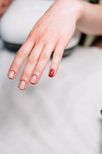 A Hand with a Red-painted Pinky and Three Unpainted Fingernails