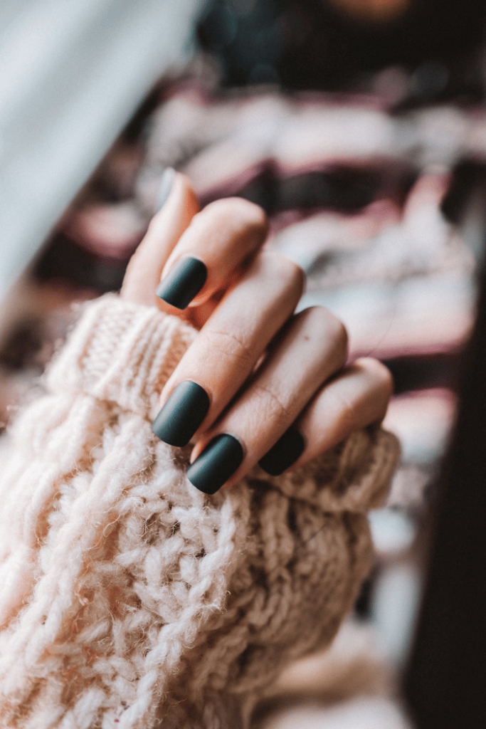 a woman wearing beautiful green fake press-on nails