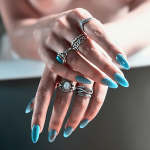 Woman Sporting Blue Press On Nails and Several Rings