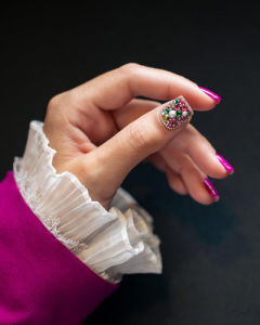 A Hand Featuring a Magenta Manicure and a Heavily-Embellished Thumb Accent Nail