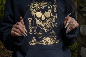 A Faceless Woman Wearing a Skeleton-themed Hoodie and Showing Off Coffin Nails Painted Nude and Decorated with Stones